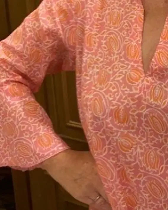 Sunni is an ultra luxurious, organic pure cotton nightie with bell sleeve in pink glow with orange. It is invariably mistaken for silk.   Extremely comfortable and light and feels beautiful to sleep in - the moment you put it on, it feels heavenly.   Elegant, ethereal and so pretty with a pretty neckline and gorgeous bell sleeve  The model is usually a size 8 but seen here in our size 12 sample   Superb workmanship and has been produced in a happy workshop well known to us under excellent working conditions