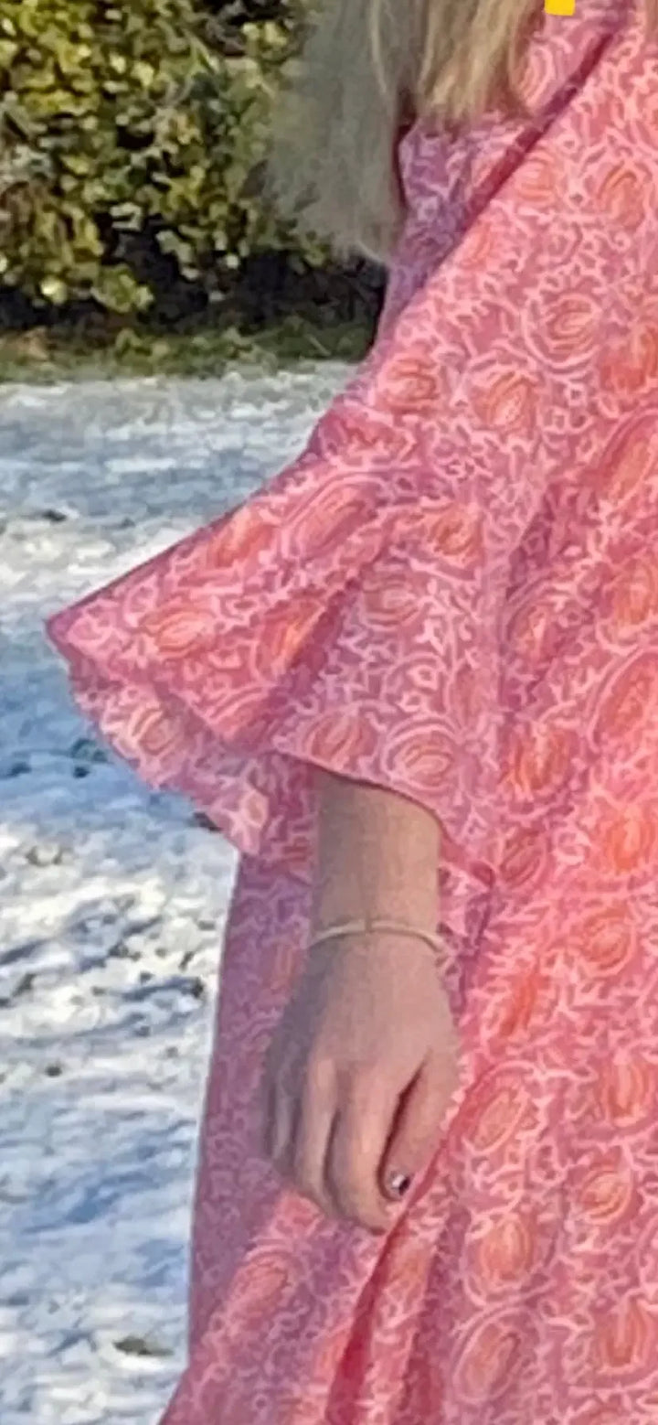 Sunni is an ultra luxurious, organic pure cotton nightie with bell sleeve in pink glow with orange. It is invariably mistaken for silk.   Extremely comfortable and light and feels beautiful to sleep in - the moment you put it on, it feels heavenly.   Elegant, ethereal and so pretty with a pretty neckline and gorgeous bell sleeve  The model is usually a size 8 but seen here in our size 12 sample   Superb workmanship and has been produced in a happy workshop well known to us under excellent working conditions