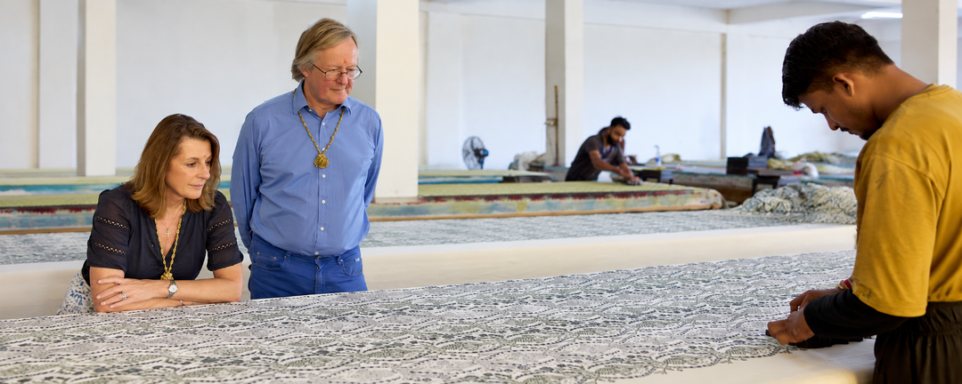 Polly Eddis, founder of Parasol-UK, and her husband Johnny watching an artisan hand block print fabric.